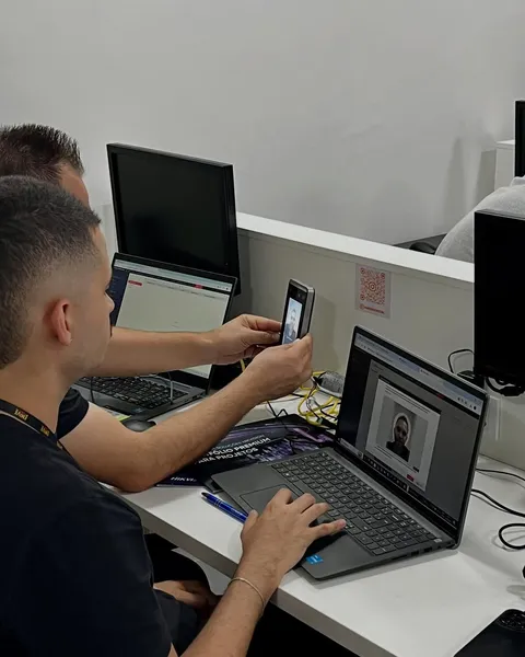 Alunos praticando a configuração do sistema no notebook e no celular durante o treinamento